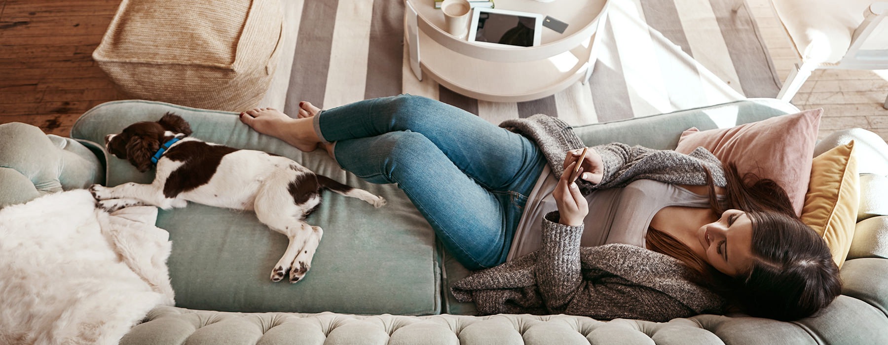 Woman laying on the couch with her dog 